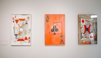 The image shows three abstract playing card paintings: King of Hearts, Ace of Clubs, and another King of Hearts, displayed on a wall.